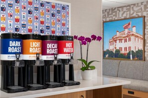 Estación de café con cuatro dispensadores etiquetados: TUEQUE, CLARO, DESCAFEINADO y AGUA CALIENTE.