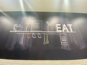 A chalkboard with the word "EAT" and various food-related drawings.