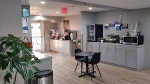 A modern kitchen area with a coffee station, a microwave, and a refrigerator. There is a table with chairs and a trash bin. - Microtel Inn & Suites by Wyndham Albertville (Albertville)