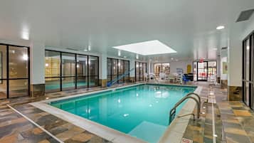 Una piscina techada, sillones reclinables de piscina