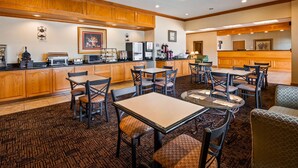 A hotel lobby with wooden cabinetry, a coffee station, and a seating area with tables and chairs. - Best Western Longview (Longview)