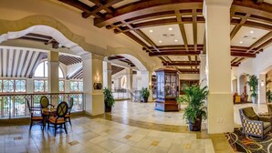 A spacious lobby with high ceilings, arched columns, and a mix of seating areas. - Rosen Shingle Creek (Orlando)