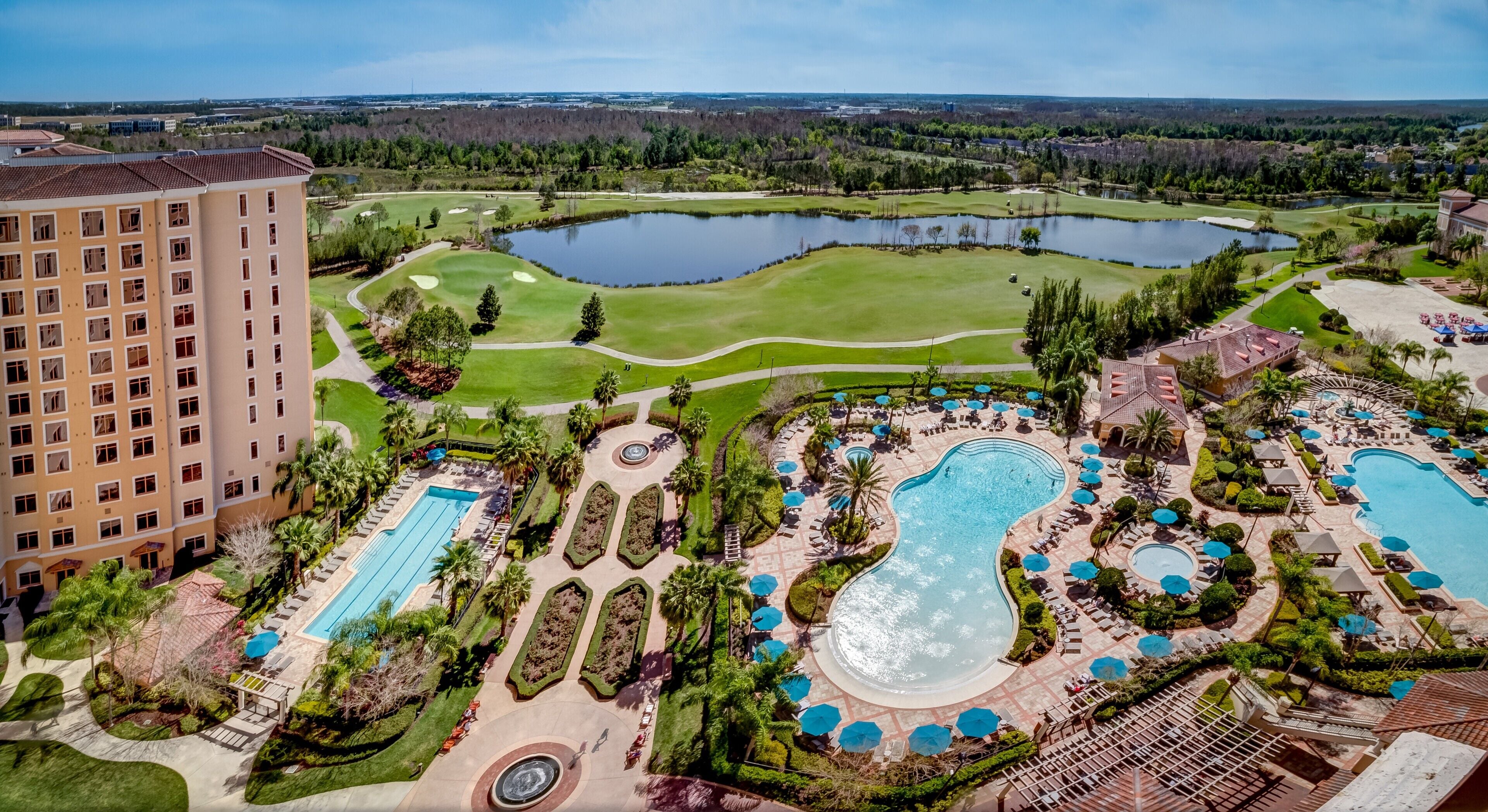 A resort with multiple swimming pools, a golf course, and a large building.