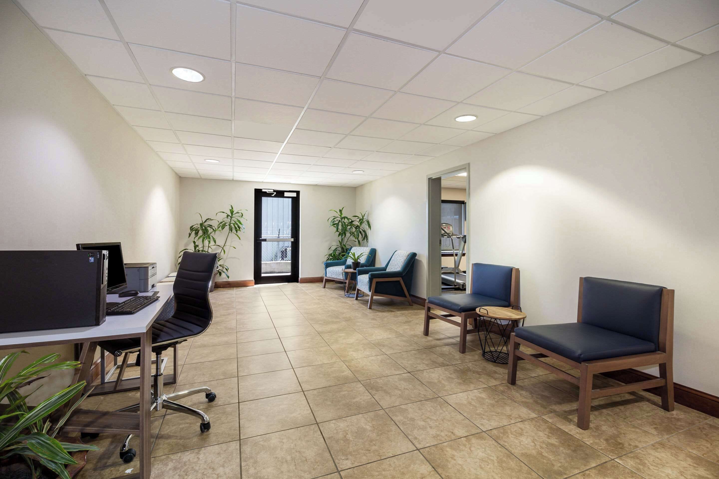 A spacious office with a reception area, a waiting area with chairs, and a desk with a computer.