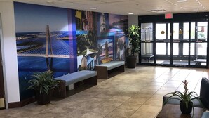 A lobby with a large mural, seating areas, and a reception desk.