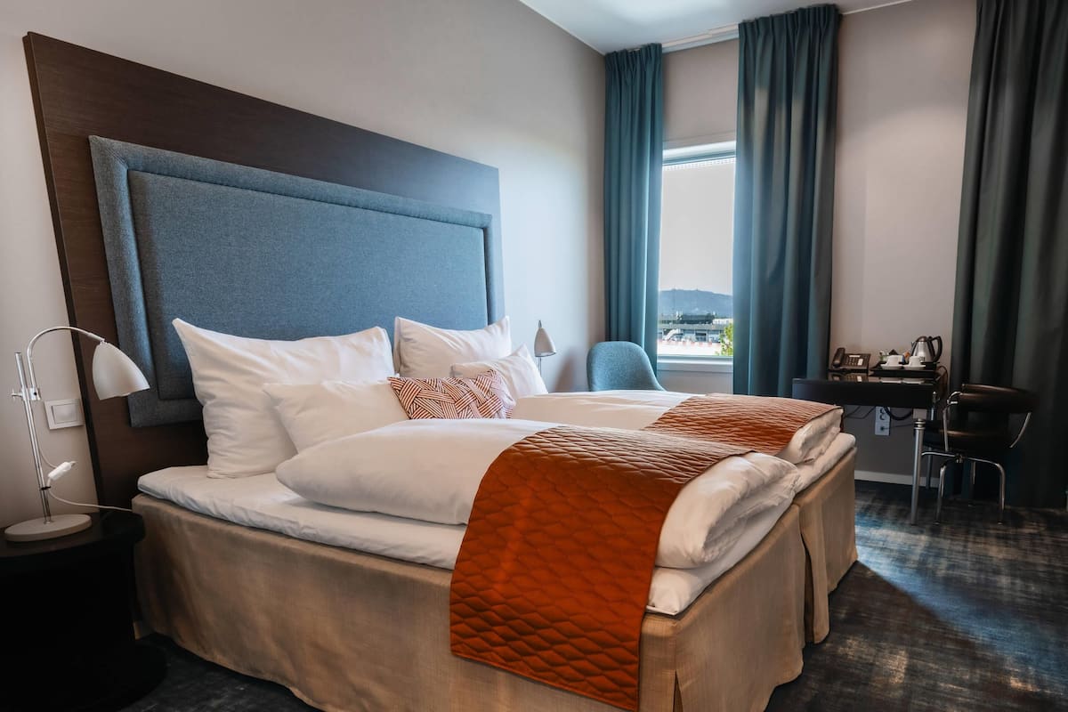 Una habitación de hotel con una cama grande, un escritorio y una silla.