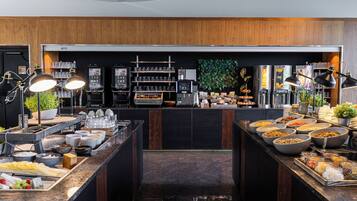 Un buffet proposant une variété de plats et de boissons, une machine à café et un espace dédié au café.