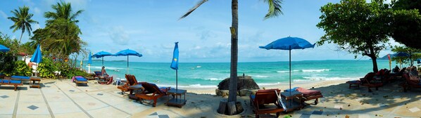 On the beach, white sand, sun loungers, beach umbrellas