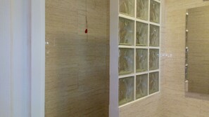 Una habitación con un ventanal grande, una pared de mármol y una puerta.