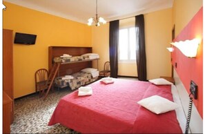 Una habitación con una cama individual superpuesta, un escritorio, una silla, un televisor y una ventana con cortinas.