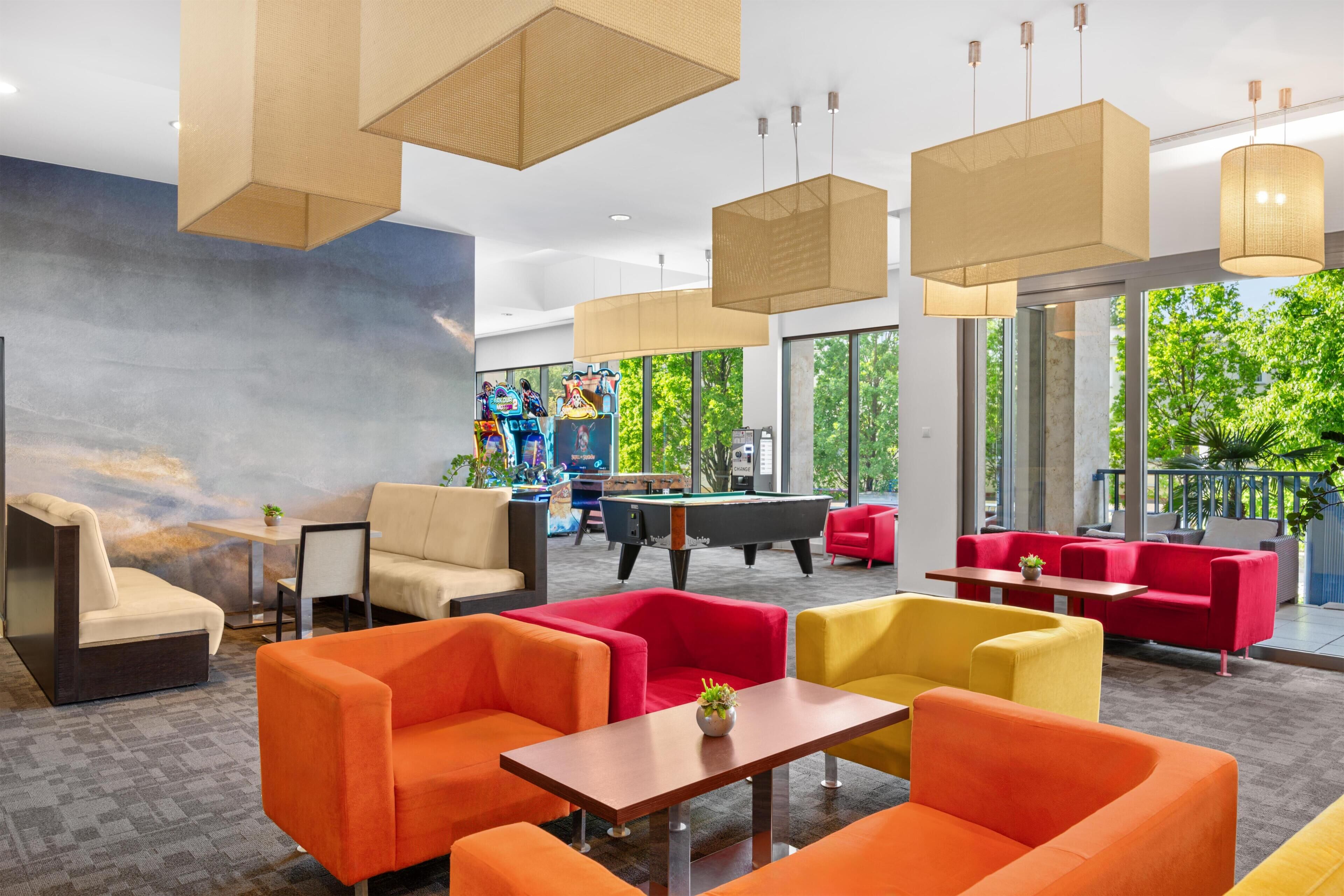 Un espace de détente moderne avec des canapés, des tables et un billard.