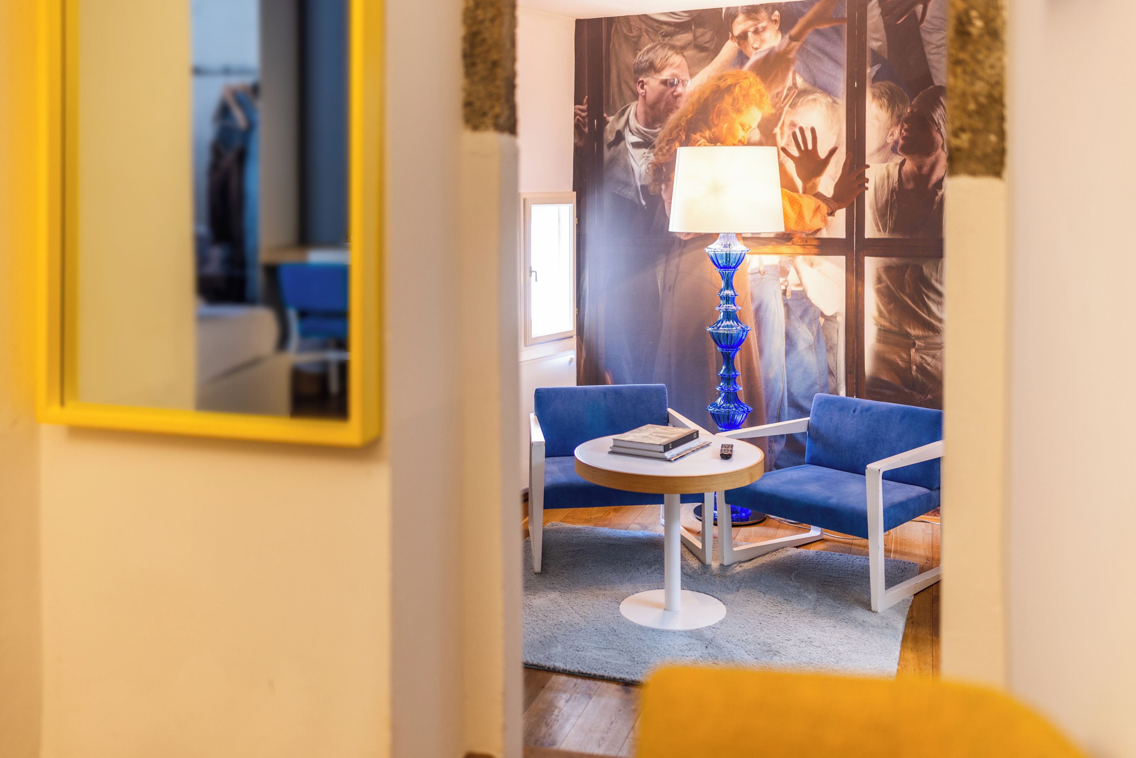 A modern room with a blue sofa, a small round table, and a lamp.