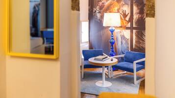 A modern room with a blue sofa, a small round table, and a lamp.