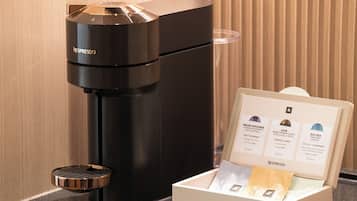 Een Nespresso koffiemachine met een houder voor koffiekapsules, met daarin drie capsules.