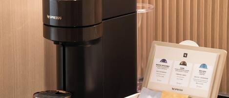 A Nespresso coffee machine with a coffee pod box containing three pods.