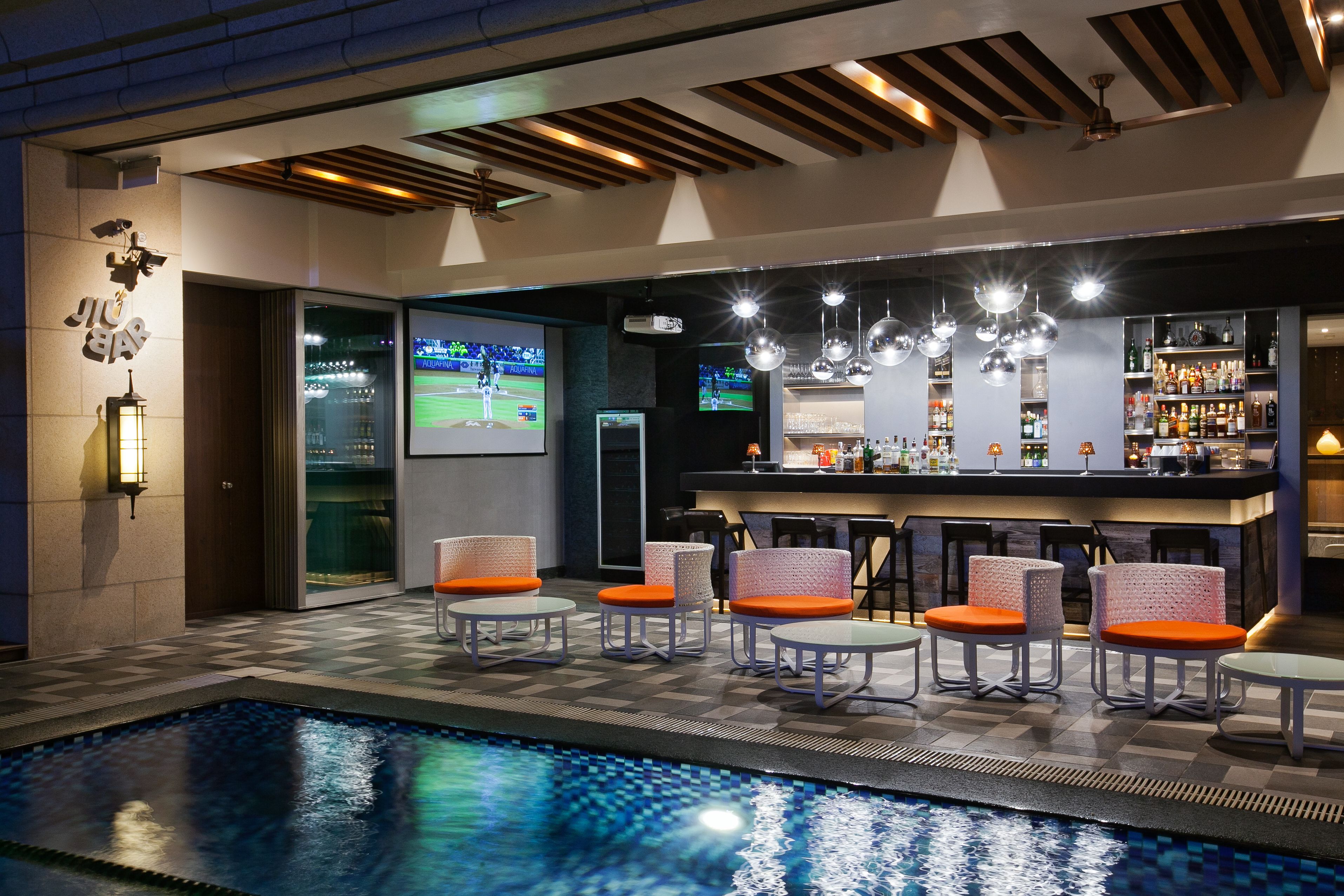 A bar area with seating and a pool.