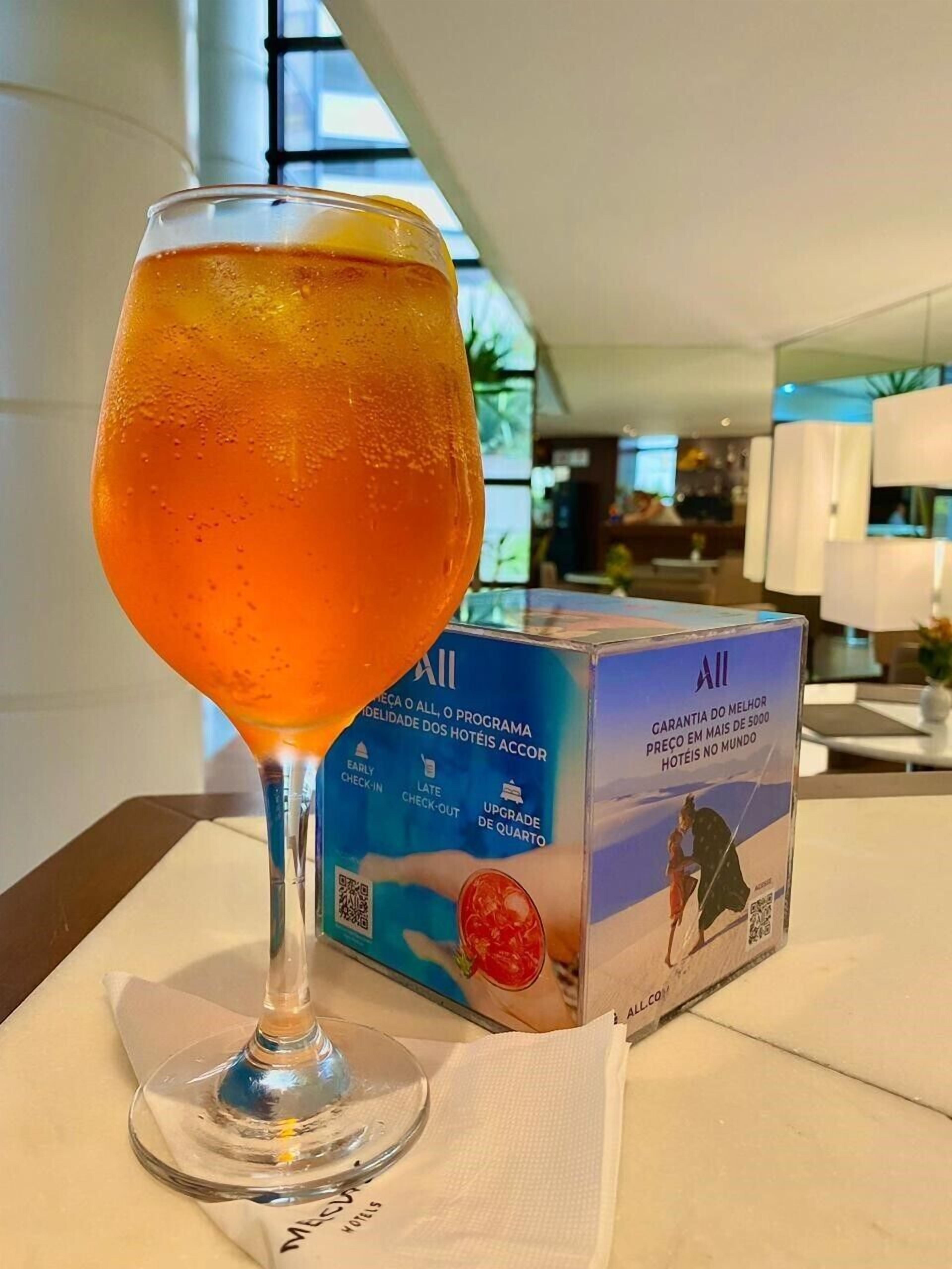 Een cocktailglas met een doos All hotels.