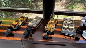 A buffet with various food items including wraps, croissants, and desserts.
