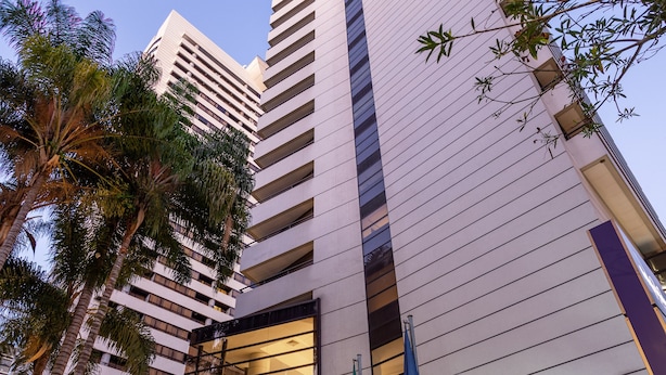 A modern hotel building with a prominent entrance, large windows, and a flag. - Mercure São Paulo Grand Plaza Paulista (São Paulo)