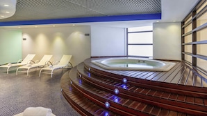 A modern spa area with a hot tub, lounge chairs, and a wooden staircase. - Mercure São Paulo Grand Plaza Paulista (São Paulo)