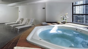 A modern indoor spa area with a hot tub, lounge chairs, and a wooden floor. - Mercure São Paulo Grand Plaza Paulista (São Paulo)