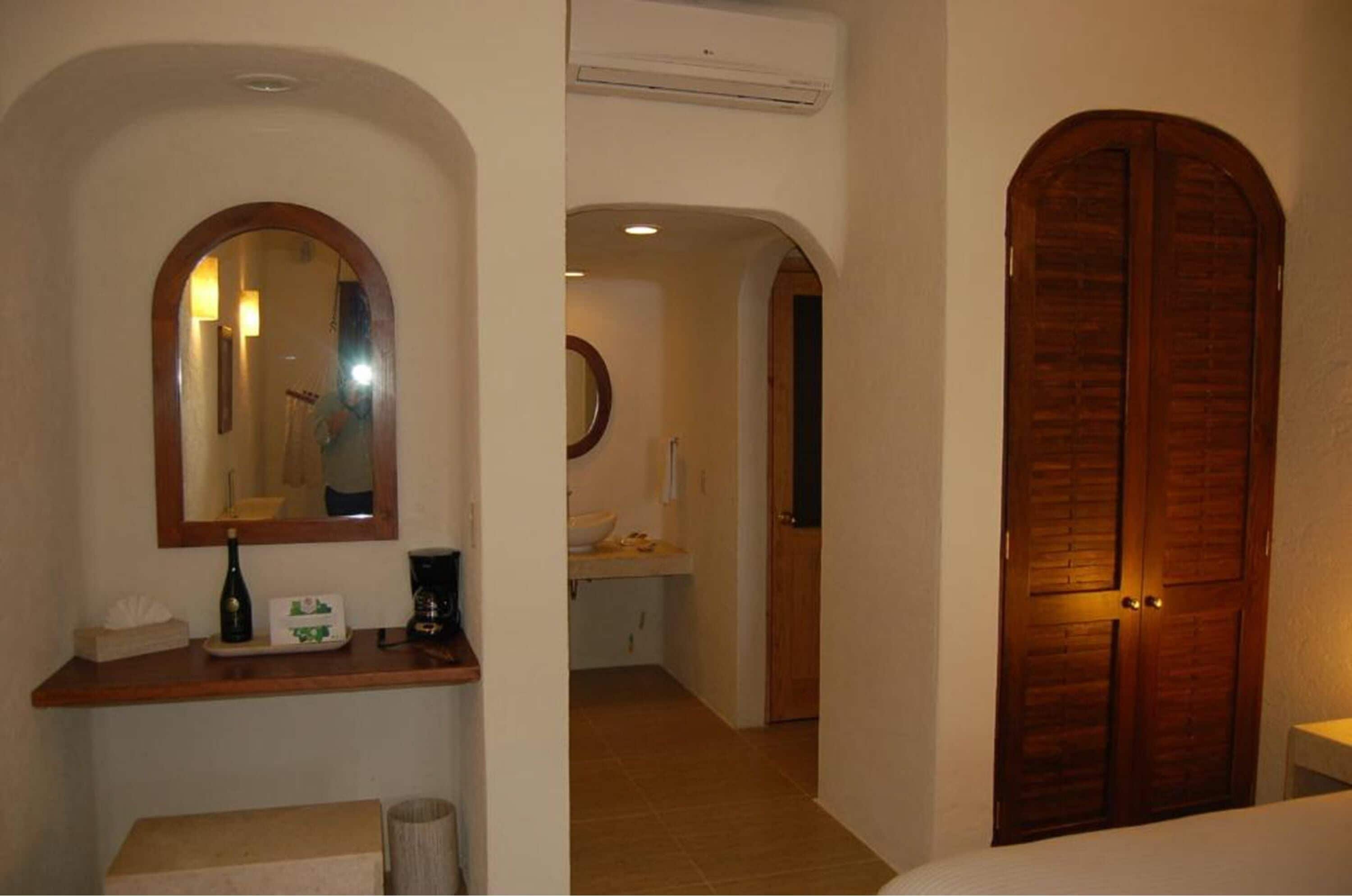 Un baño con tocador de madera, espejo y lavamanos.
