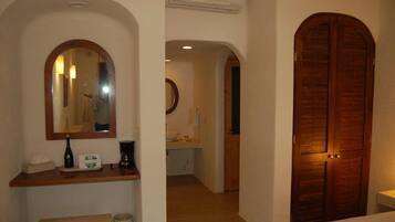 Un baño con tocador de madera, espejo y lavamanos.