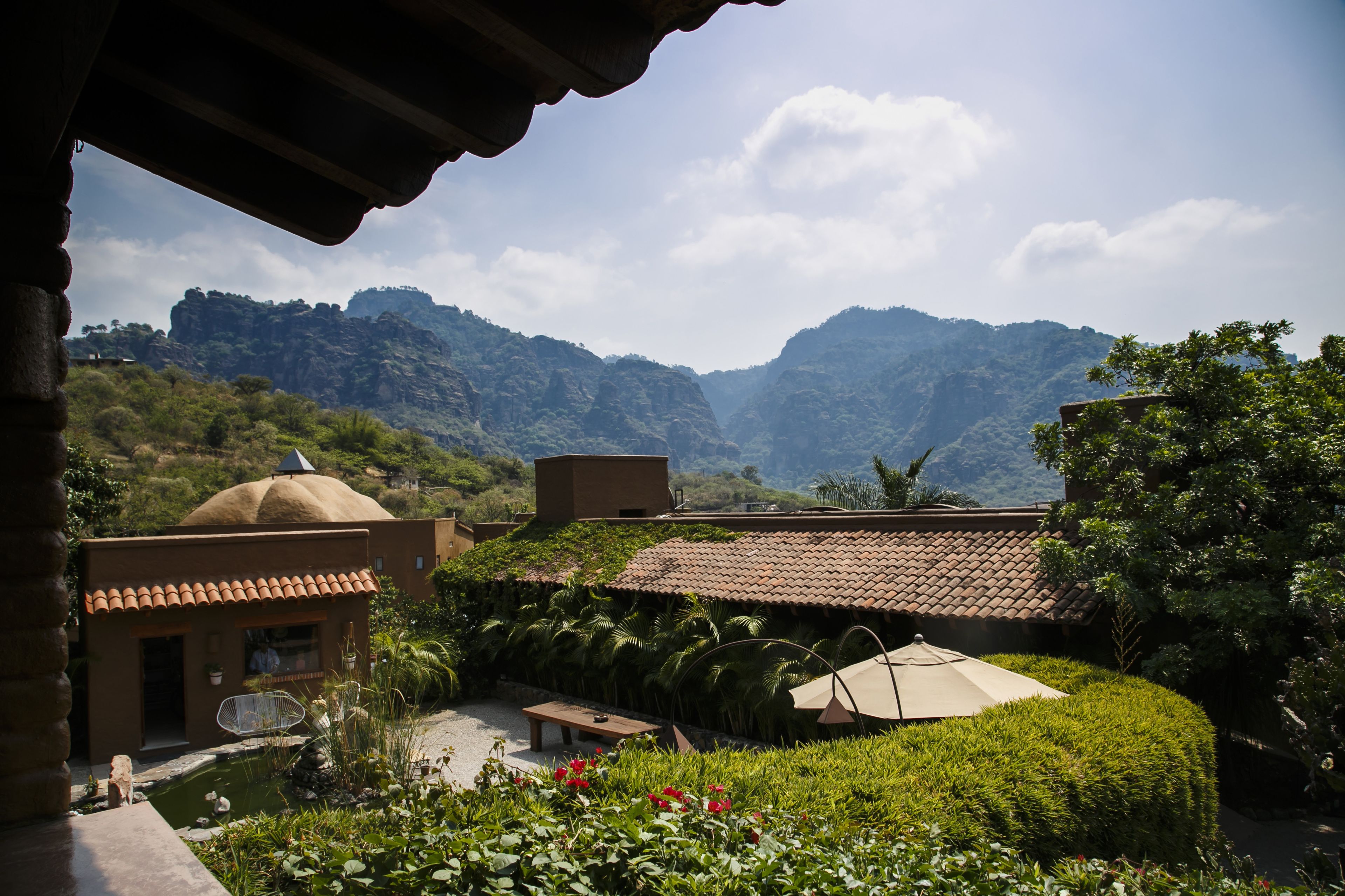 A courtyard with a small pool, a gazebo, and a view of mountains.