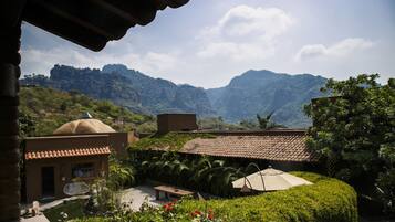 A courtyard with a small pool, a gazebo, and a view of mountains.