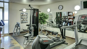 A gym with cardio machines, weight machines, and a mirror. - Lakeview Inns & Suites - Slave Lake (Slave Lake)
