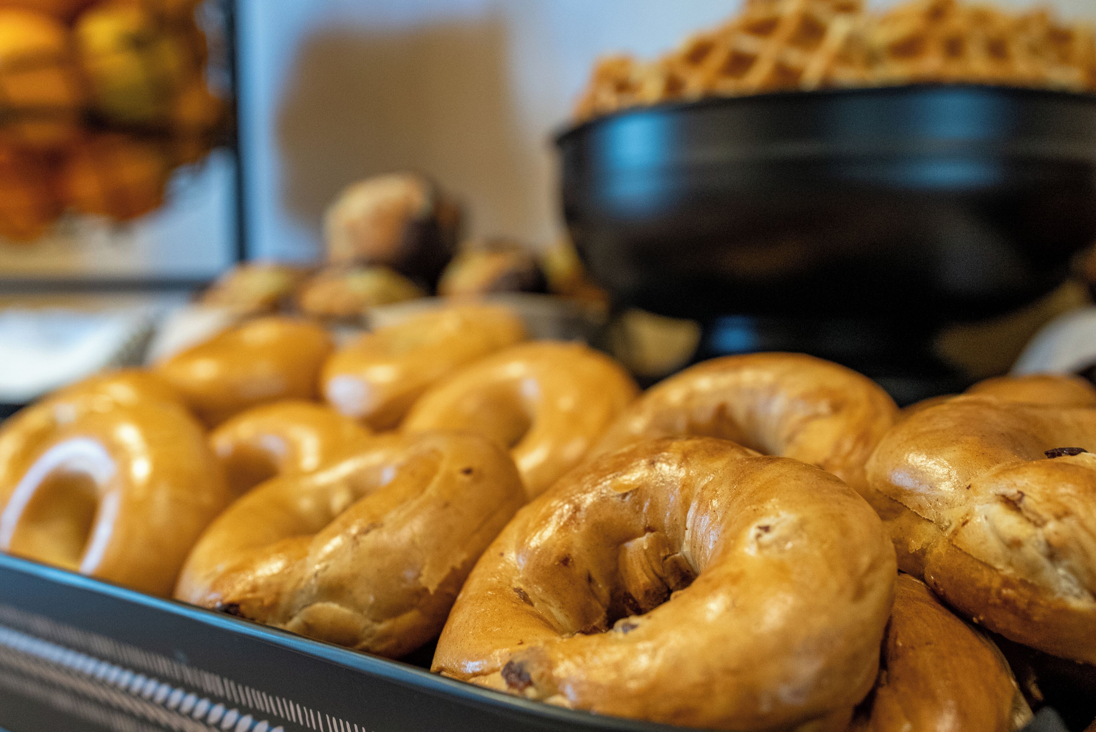 En bricka med bagels, och i bakgrunden en skål med soppa.