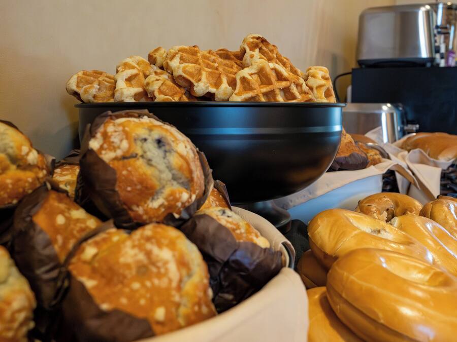 A variety of baked goods including waffles, muffins, and pastries in a bowl.