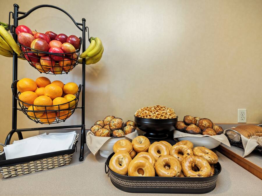 Un bufé de desayuno con frutas, donas, gofres y pastelería.