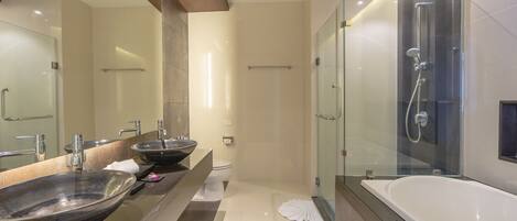 A modern bathroom with a large mirror, two sinks, a bathtub, and a glass-enclosed shower.