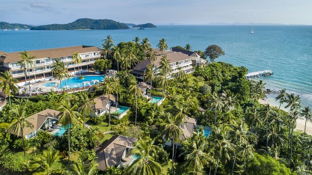 A resort with multiple swimming pools, a beach, and a view of the ocean.