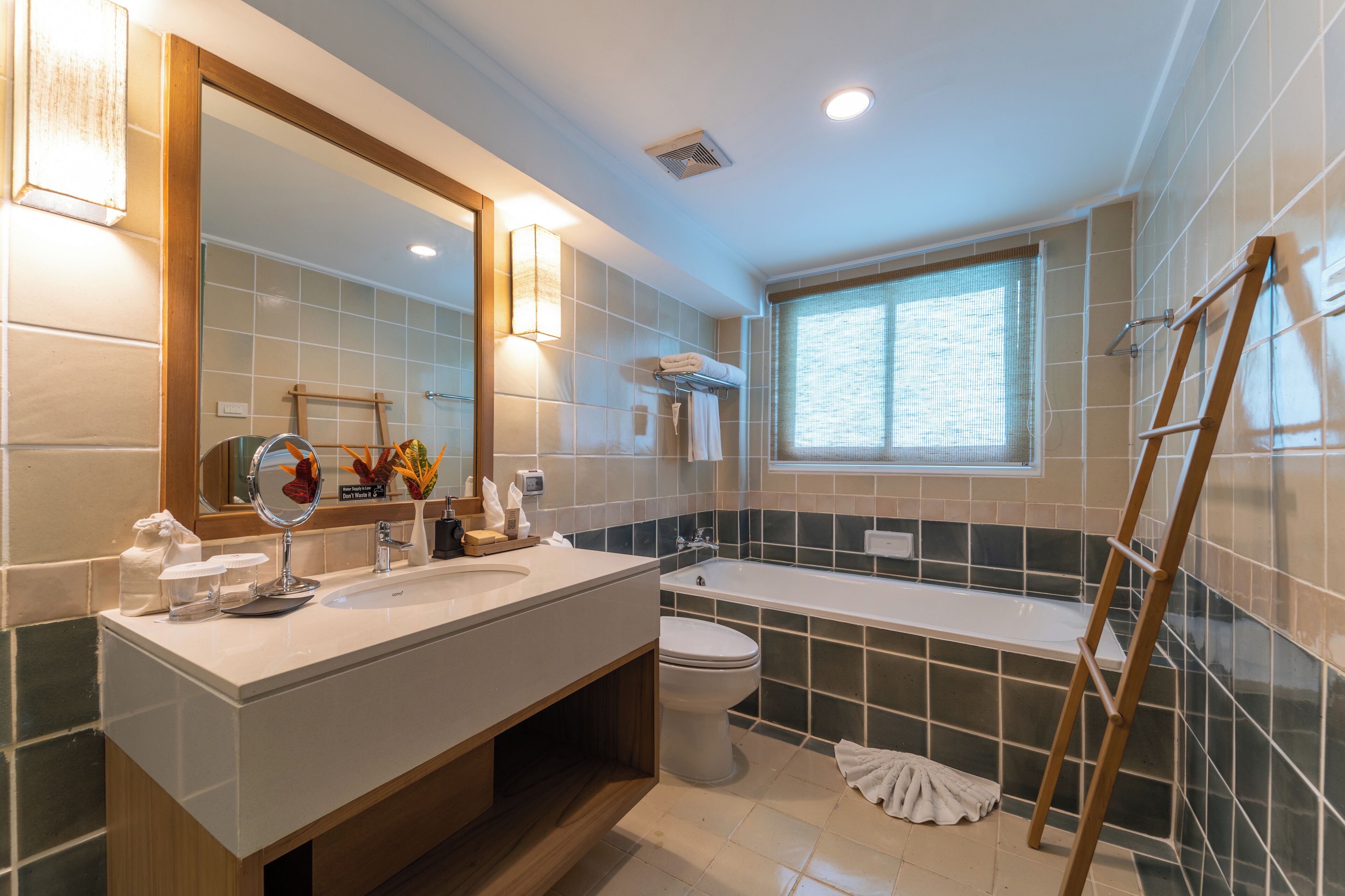Un baño moderno con un espejo grande, lavamanos dobles, una bañera y una ventana.