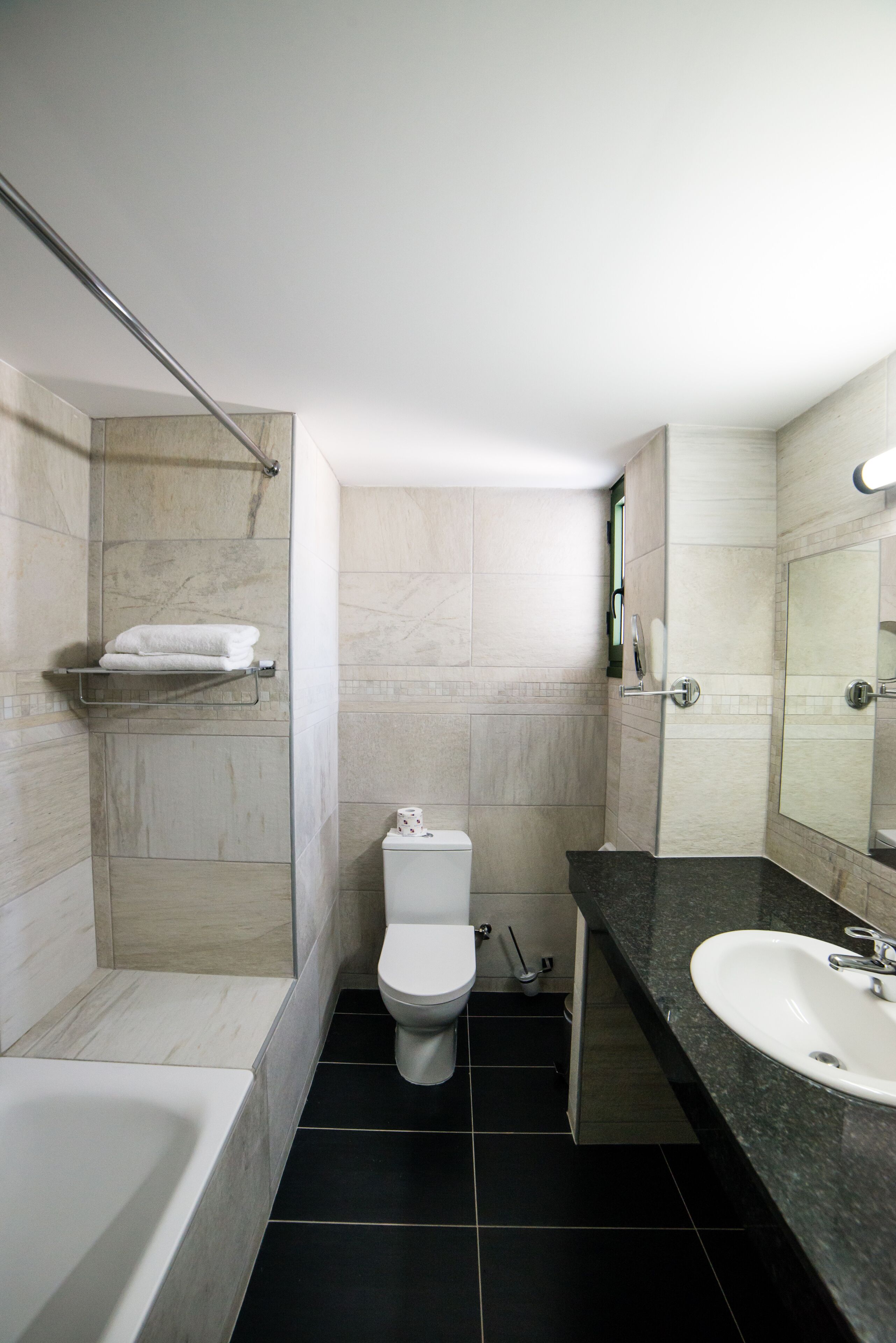A modern bathroom with a bathtub, toilet, and sink.