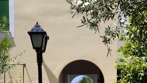 A pathway leading to a beach with a lamp post and greenery on either side. - Kefalos Beach Tourist Village (Paphos)