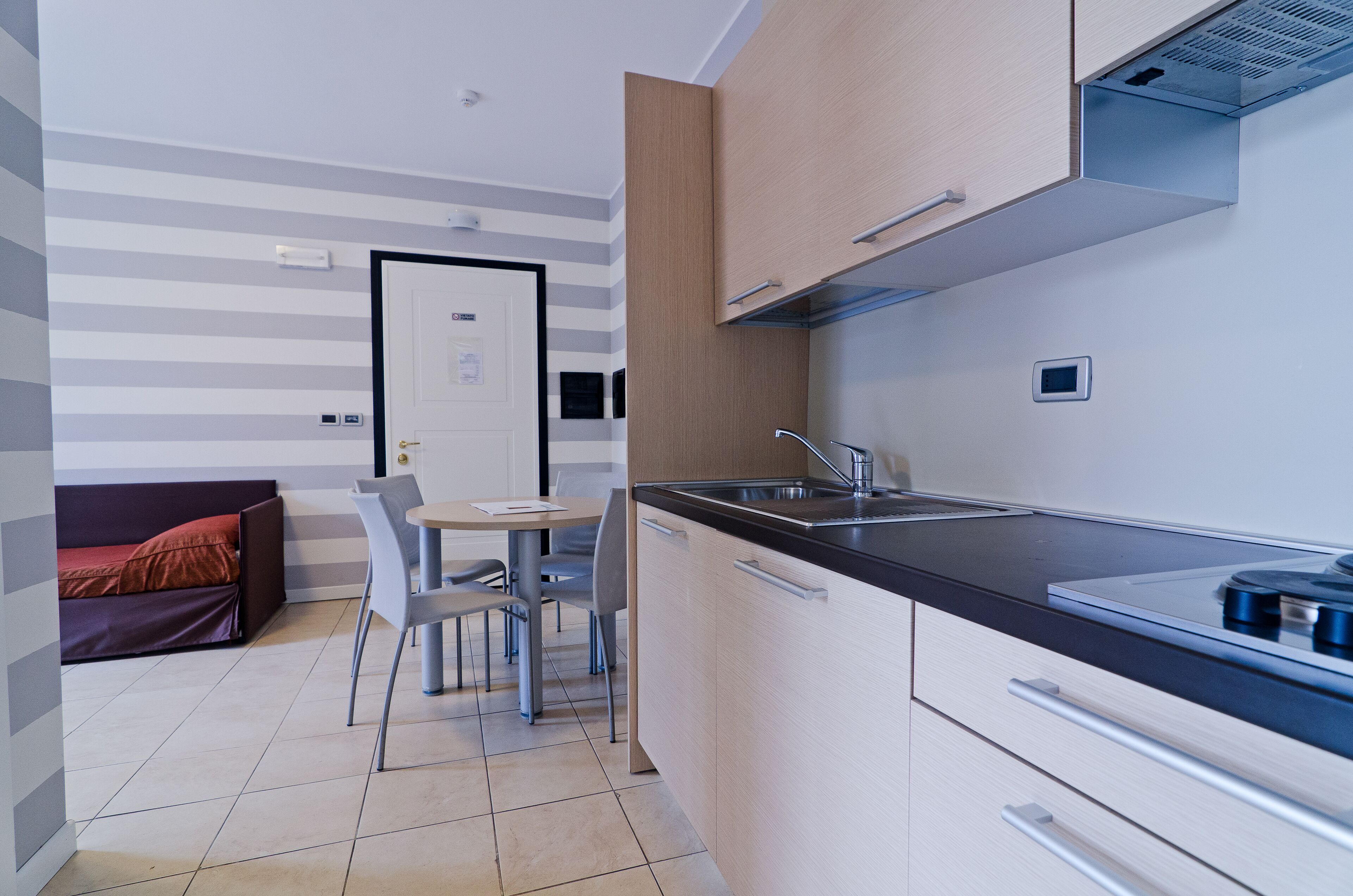 Une cuisine compacte avec un coin repas, une cuisinière intégrée et une petite fenêtre.