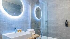 A modern bathroom with a large mirror, a sink, and a glass-enclosed shower. - ibis Styles Crolles Grenoble A41 (Crolles)