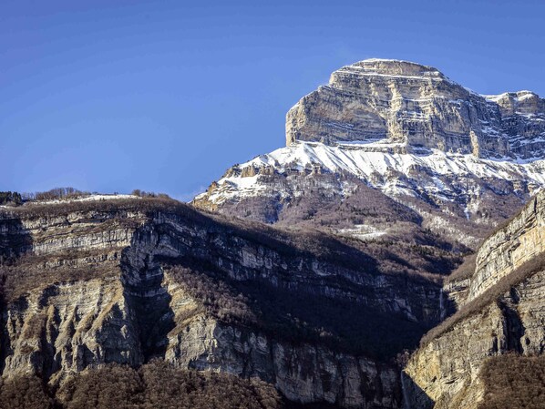 Paisaje montañoso con un pico destacado y formaciones rocosas escalonadas.
