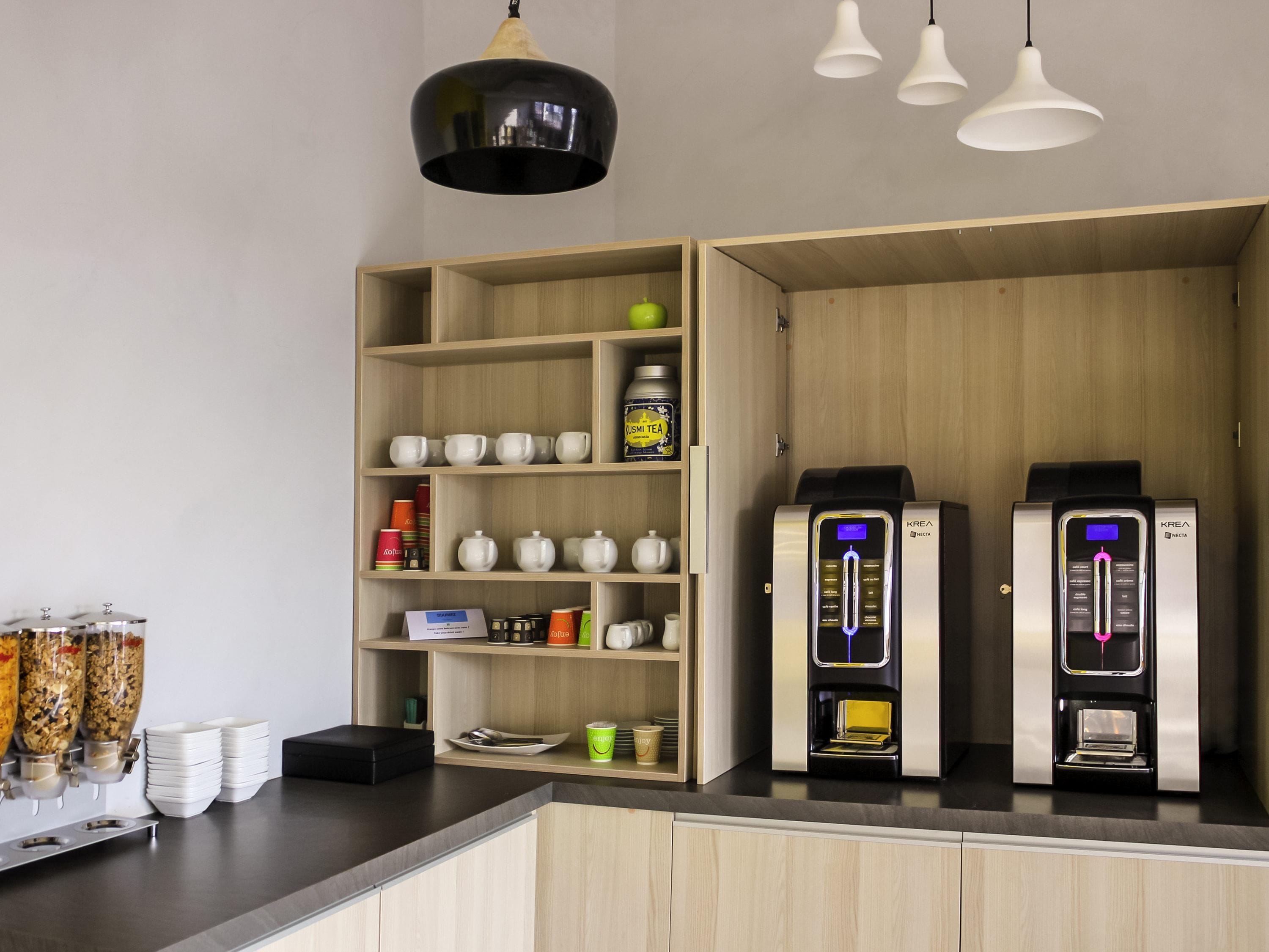 Una cucina moderna con mobili in legno, un angolo caffè e due macchine da caffè.