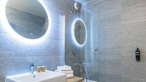 A modern bathroom with a large mirror, a sink, and a bathtub. - ibis Styles Crolles Grenoble A41 (Crolles)