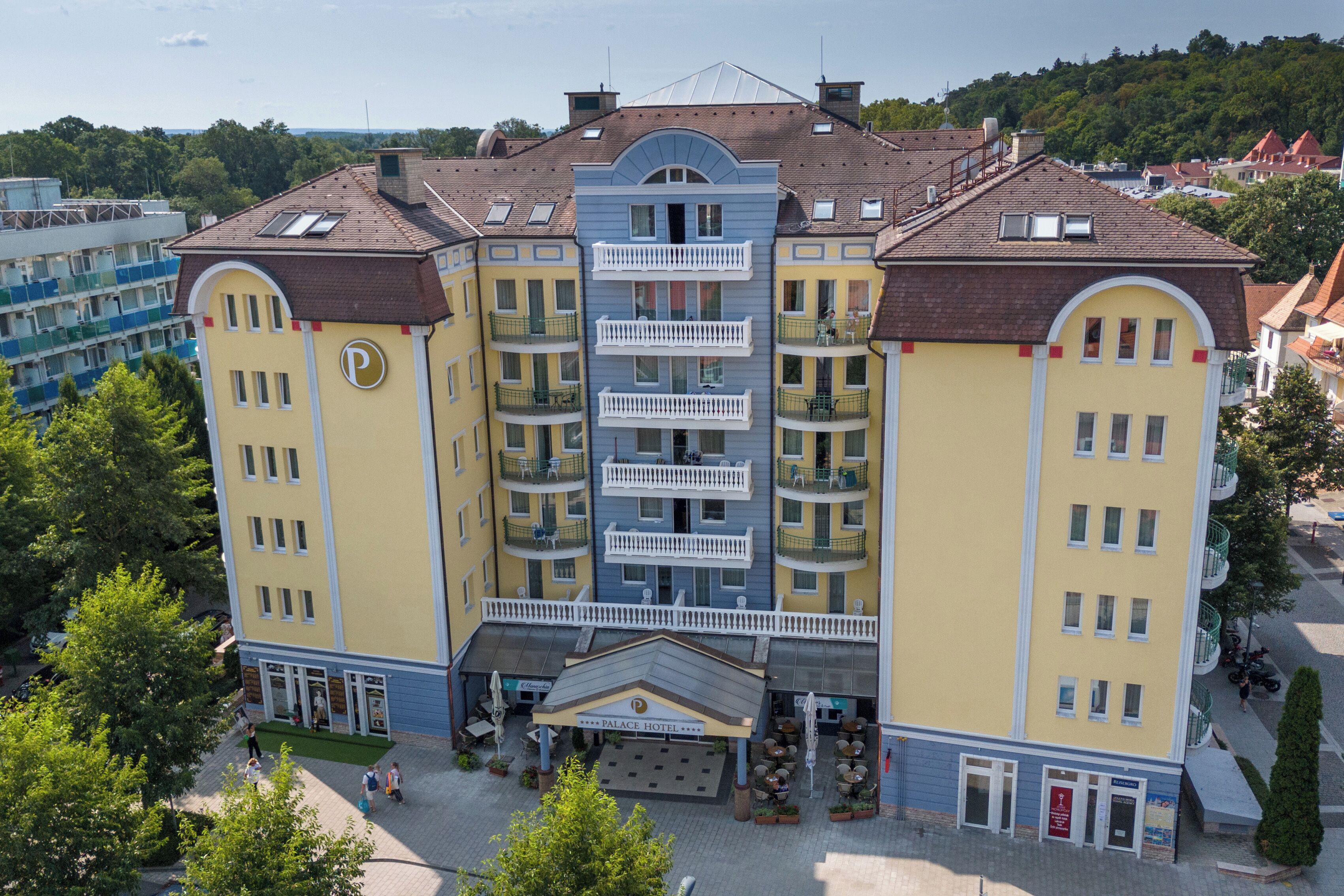 A multi-story hotel with a central courtyard, balconies, and a sign indicating it is a hotel.