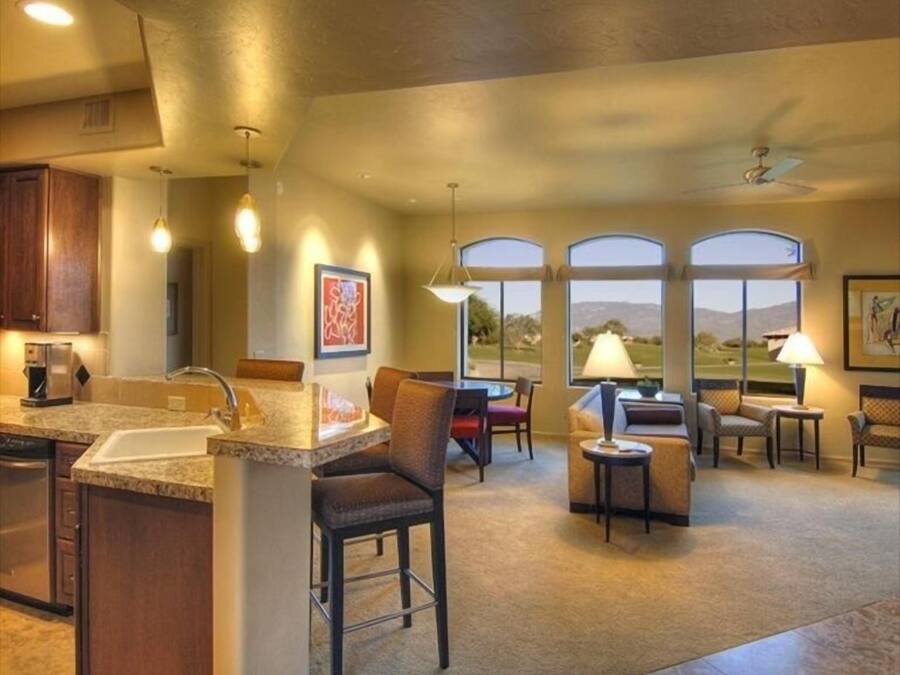 A spacious kitchen with a large island, bar stools, and a dining area with a view.