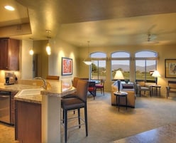 Una cocina amplia con una isla grande, taburetes de bar y un comedor con vistas.
