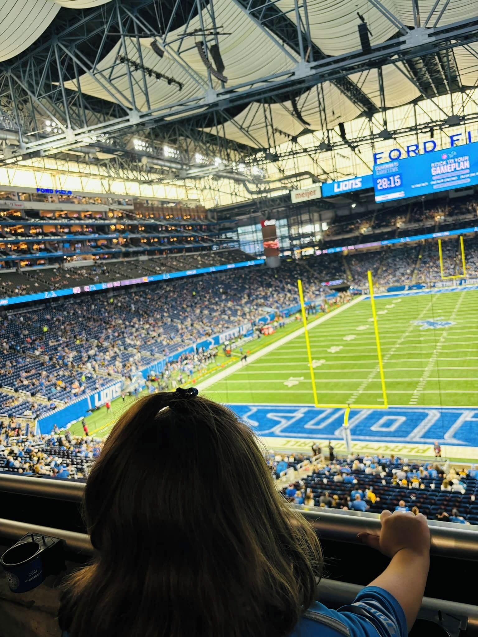 A stadium with multiple tiers of seating, a large scoreboard, and a visible field.