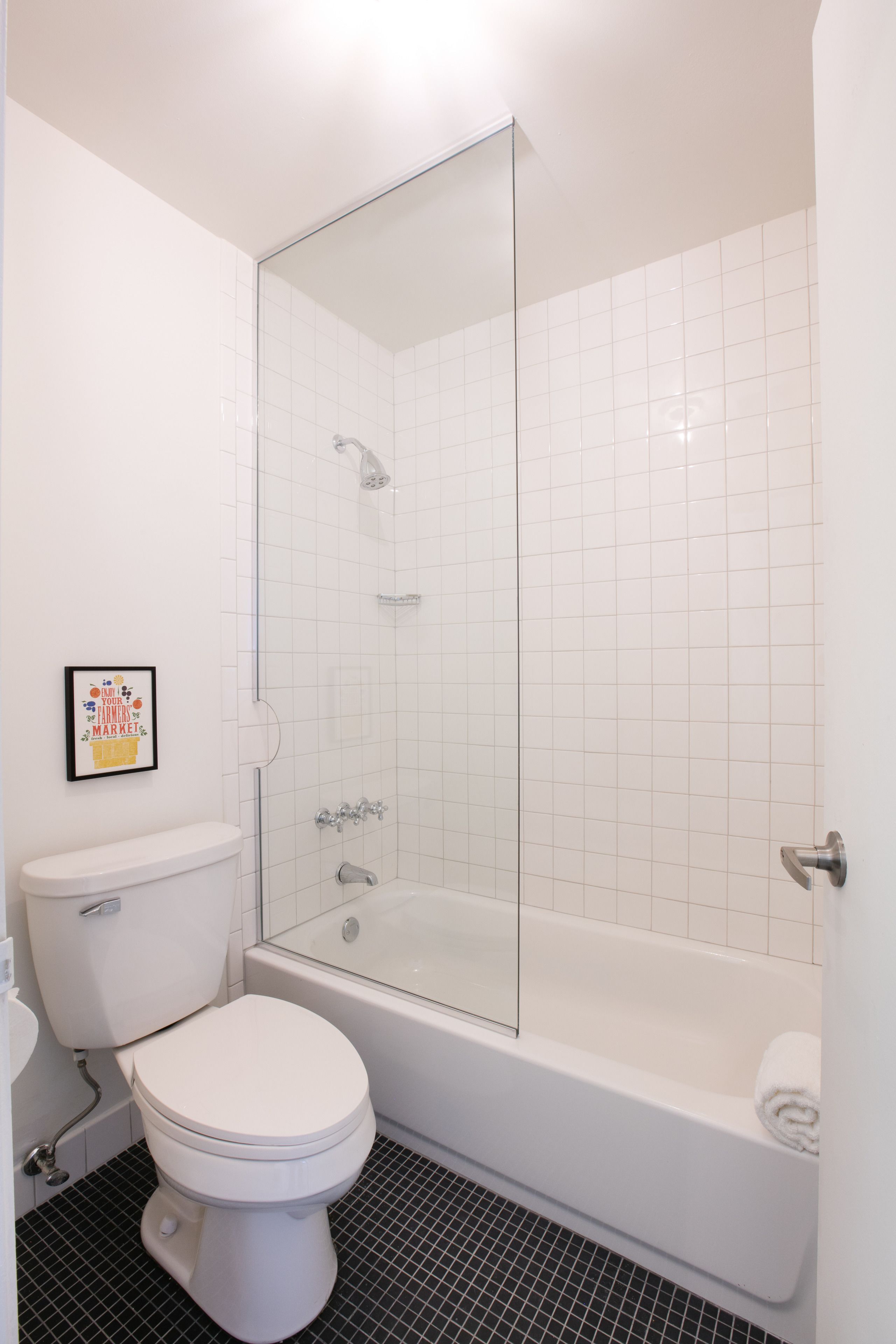 Een badkamer met toilet, bad en douchecabine.