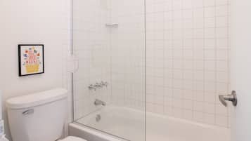Een badkamer met toilet, bad en douchecabine.