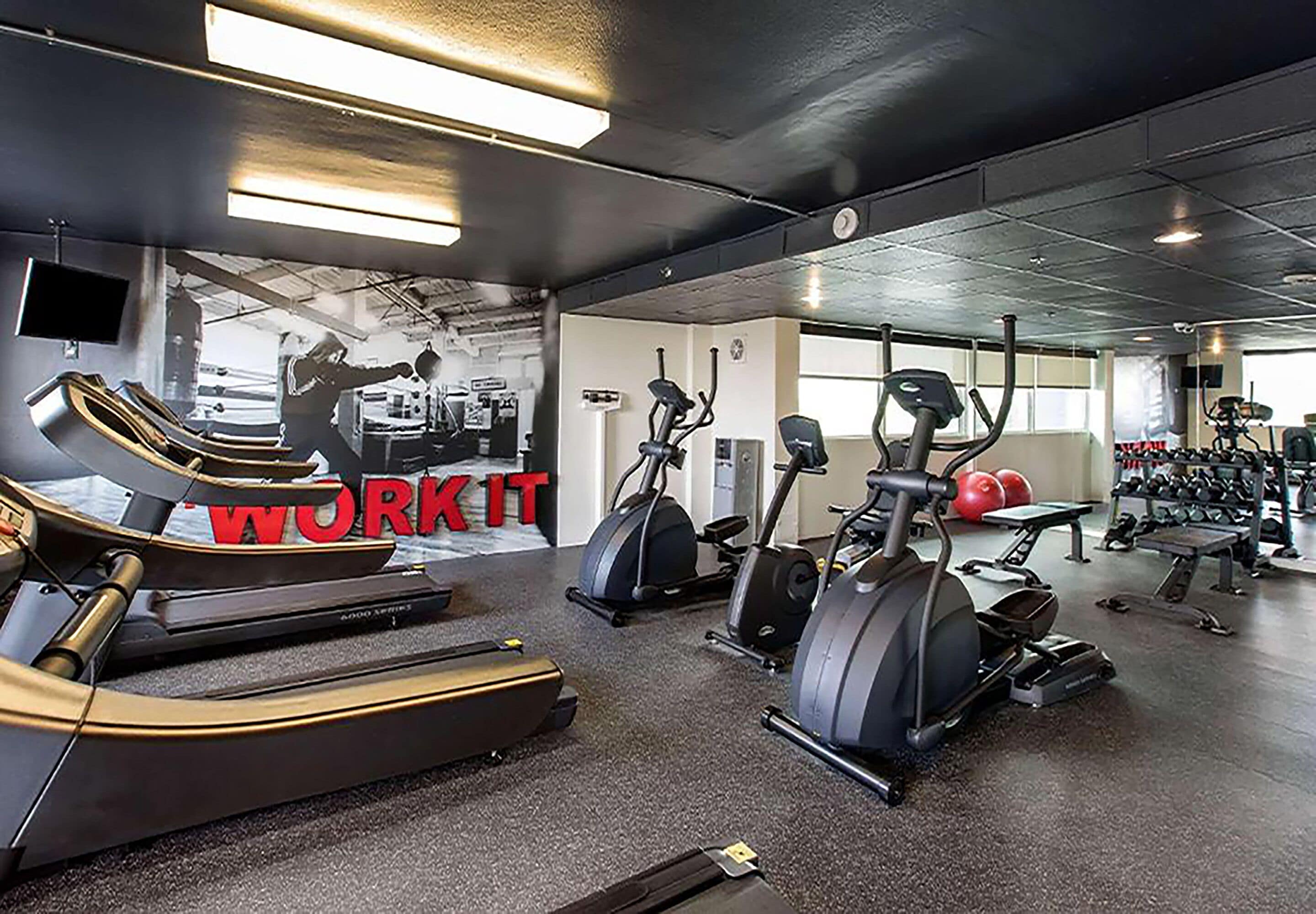 A gym with treadmills, elliptical machines, and weight equipment.